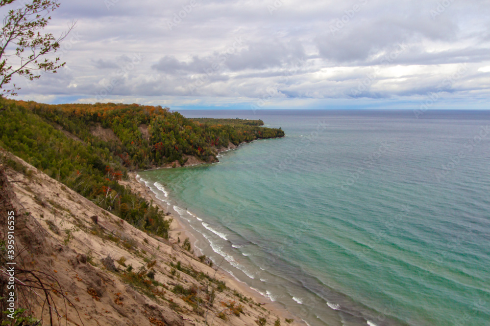 Steep Cliff On Coast. Massive sand dune forms a large cliff on the coast of Lake Superior at the popular Log Slide Overlook along the Pictured Rocks National Lakeshore in Michigan. Steep Cliff On Coast. Massive sand dune forms a large cliff on the coast of Lake Superior at the popular Log Slide Overlook along the Pictured Rocks National Lakeshore in Michigan.
