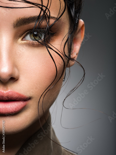 Obraz na plátně Closeup portrait of a beautiful young fashion woman with glamour makeup posing at studio