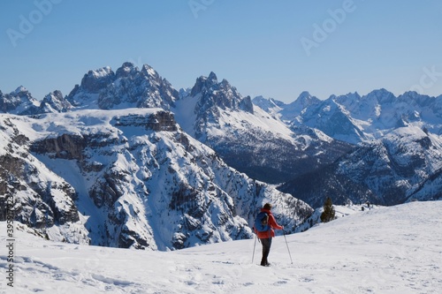 Mountain view with silhouette of walking tourist in red jacket in beautiful winter sunny scenery. Strudelkopf, Platzwiese (Piazza Prato), Dolomites, Italy © Iwona