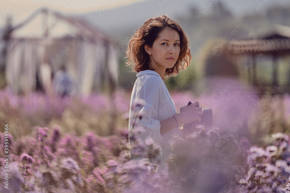 woman professional photographer on a flower field in summer