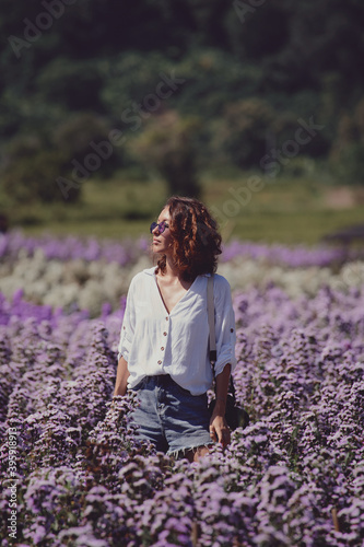 Obraz na płótnie young woman professional photographer on a flower field in summer w salonie