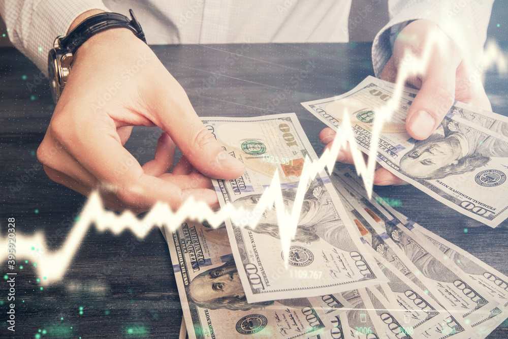 Multi exposure of financial graph drawing hologram and USA dollars bills and man hands. Analysis concept. Multi exposure of financial graph drawing hologram and USA dollars bills and man hands. Analysis concept.