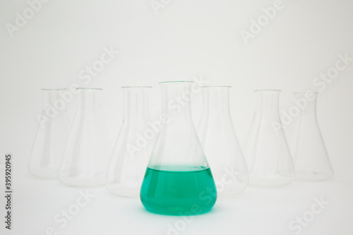 Obraz na plátně Scientific laboratory glass erlenmeyer flask filled with green liquid with glassware equipment on white background