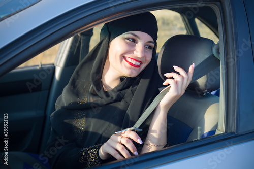 Muslim woman fastening car seat belt