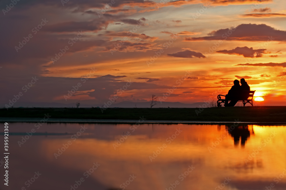 Photos of people in silhouette sitting on the bench at sunset