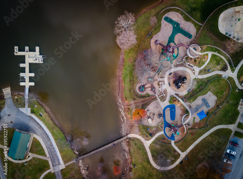 Aerial view of the playground next to Jacobson park lake in Lexington, Kentucky with pedestrian bridge leading to paddle boats dock next to it photo