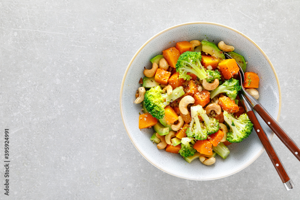 Vegetable salad bowl of broccoli, baked pumpkin, avocado and nuts. Healthy vegan food Vegetable salad bowl of broccoli, baked pumpkin, avocado and nuts. Healthy vegan food