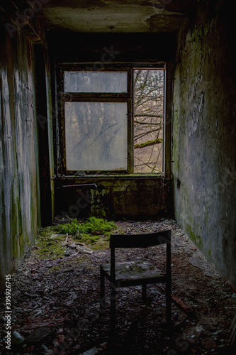 A lonely abandoned chair left opposite the window in the ghost town of Pripyat, Chernobyl in Ukraine.