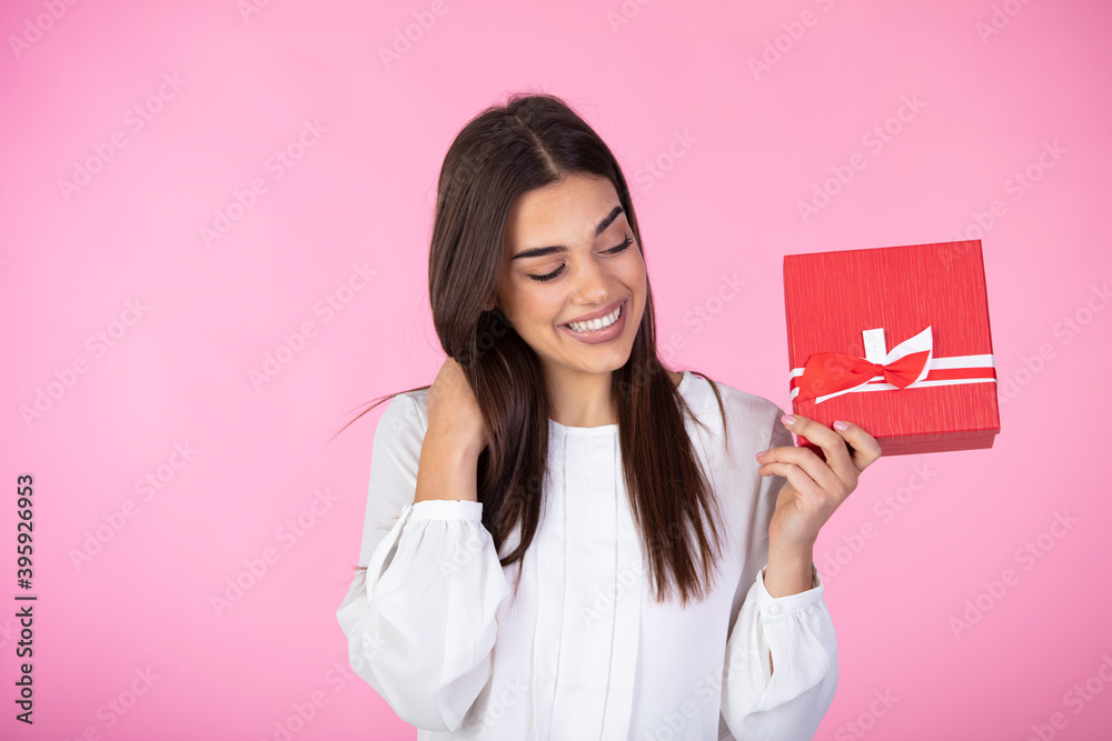 Business woman holding red gift box. Toothy smiling face. Isolated background. Beautiful happy woman holding gift box. Birthday or Valentine`s day celebrating concept Business woman holding red gift box. Toothy smiling face. Isolated background. Beautiful happy woman holding gift box. Birthday or Valentine`s day celebrating concept
