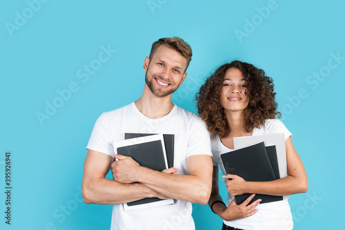 Two mixed race people standing on blue background