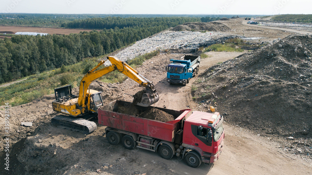 Aerial view of construction works. Earthmoving at open pit mining. Heavy equipment. Excavator loads ground in truck.