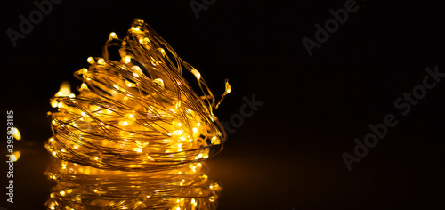 Spirituelle Weihnachtiiche beleuctung in Form eines gelben Bokehs auf einem schwarzen Hintergrund.