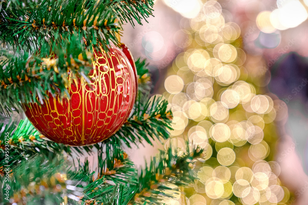 Fototapeta premium Decorations of Christmas. Colorful ball on green branch o christmas tree with bokeh of lights on background.