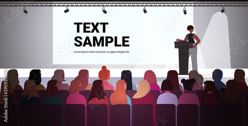 african american woman speaking to audience from tribune women's club girls supporting each other union of feminists concept conference hall interior horizontal full length copy space vector