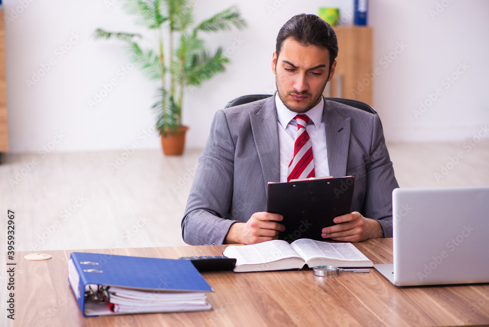 Young male employee working in the office Young male employee working in the office