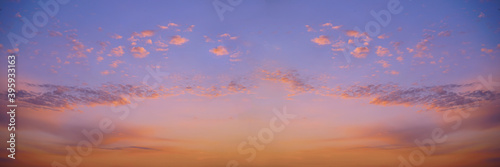 Beautiful background of the evening blue sky with colorful clouds. Purple red orange sunset. Wide banner.
