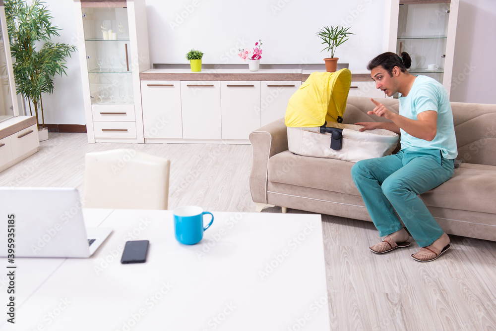 Young male parent looking after newborn at home Young male parent looking after newborn at home