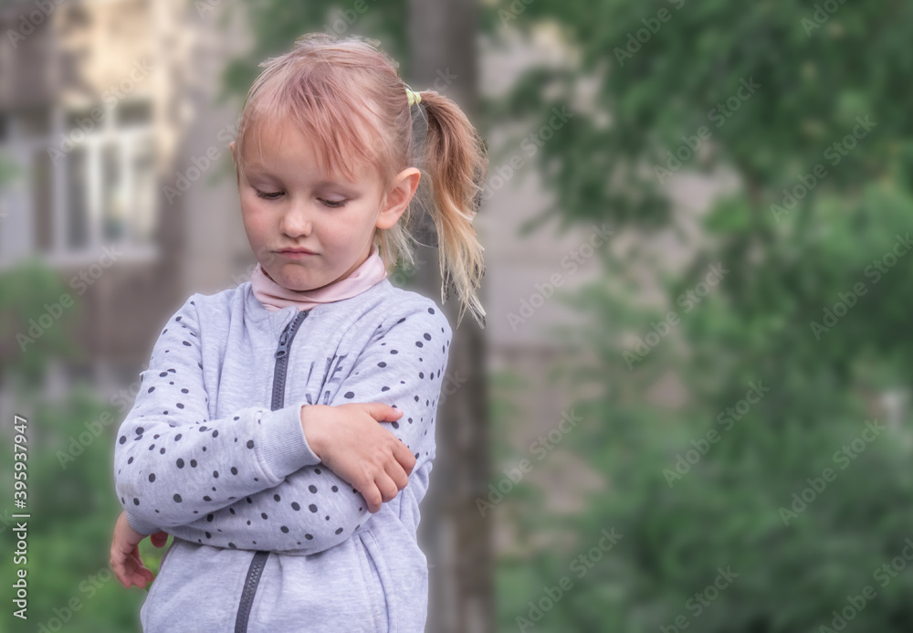 Girl 5 years old blonde European is standing with crossed arms in the park you are unhappy with something. Girl 5 years old blonde European is standing with crossed arms in the park you are unhappy with something.