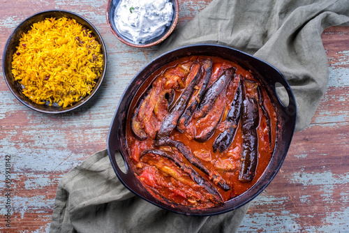 Modern style slow cooked Persian lamb eggplant stew khoresh bademjan served with rice and yoghurt as top view in a design pot photo