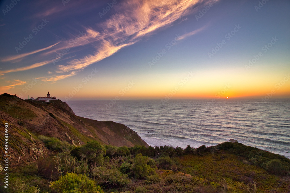 Sunset over the sea with the Cabo da Roca lighthouse Sunset over the sea with the Cabo da Roca lighthouse