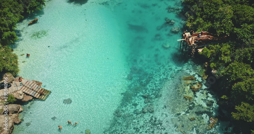 Tropical turquoise saltwater lake at green tropic landscape. Tourists recreation and relaxation in salt water lagoon of Weekuri, Indonesia, Asia. Picturesque summer vacation at exotic loch photo