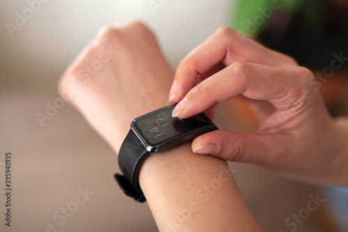 Close-up of a woman checking time on her smart watch.Modern clock concept.Background woman hand wear wrist watch.