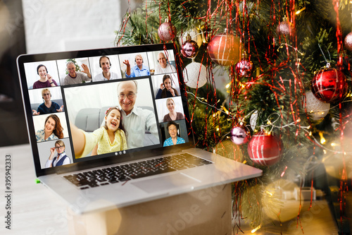 laptop with video call and christmas tree with lights in the background