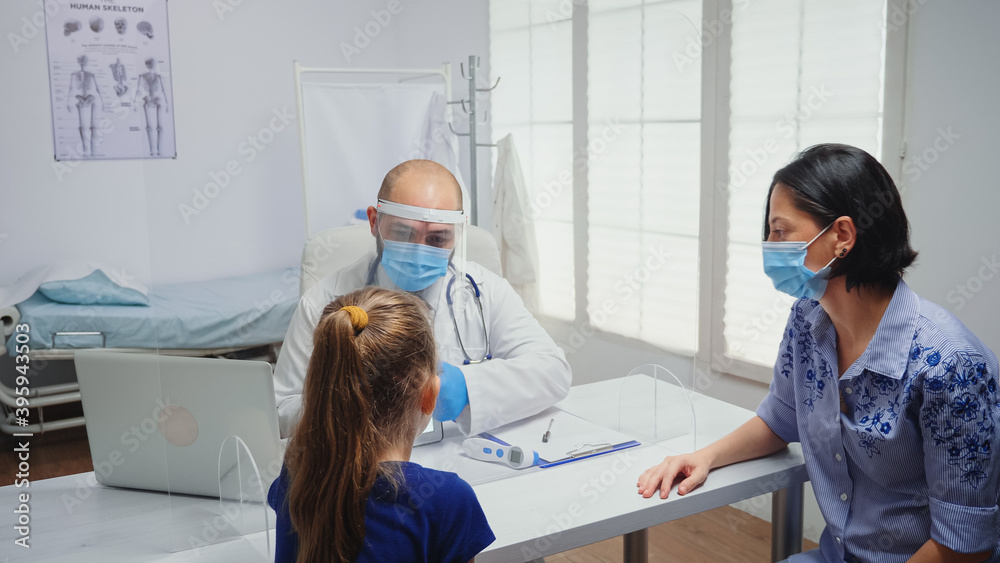 Doctor with protective gloves showing skeleton on tablet to girl. Physician specialist in medicine providing health care services consultation treatment examination in hospital cabinet during covid-19