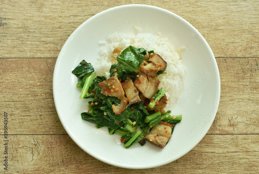 stir fried Chinese kale with crispy pork and rice on plate stir fried Chinese kale with crispy pork and rice on plate