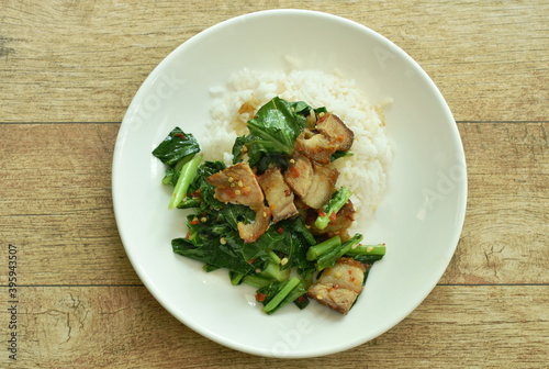 stir fried Chinese kale with crispy pork and rice on plate