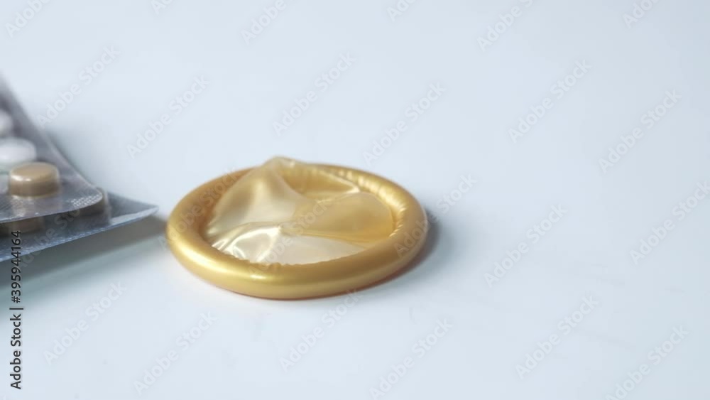 close up of condom and birth control pill on white 