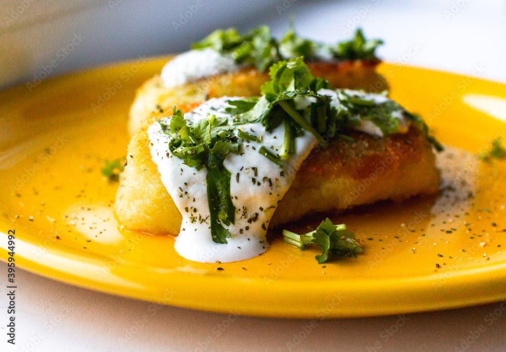 Potato patties (zrazy) stuffed with onion and mushrooms, served with greenery (cilantro), spices and cream sauce. Potato patties (zrazy) stuffed with onion and mushrooms, served with greenery (cilantro), spices and cream sauce.