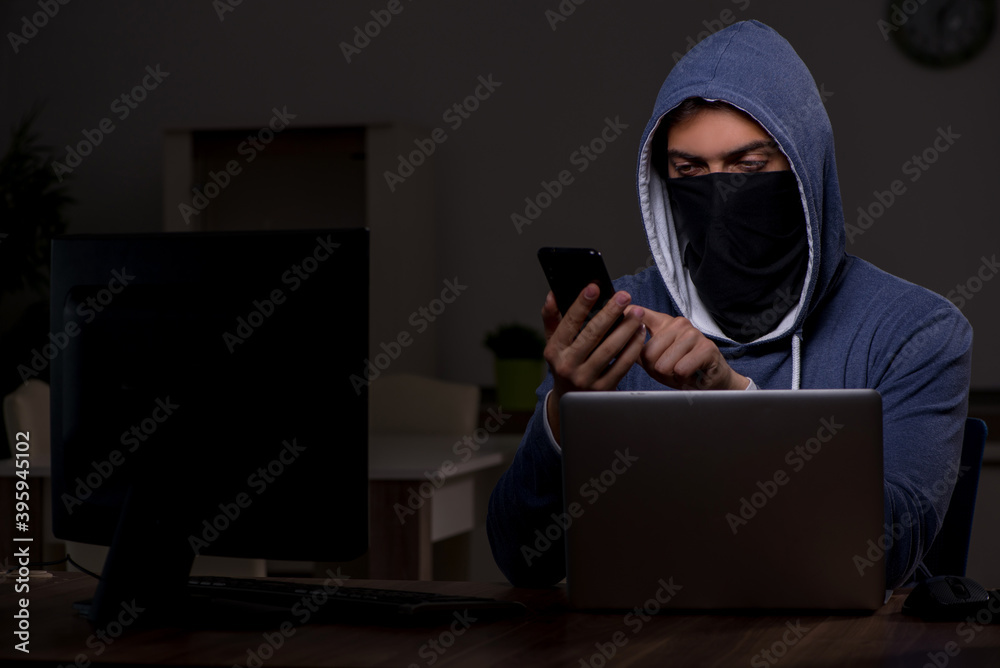 Male hacker hacking security firewall late in office Male hacker hacking security firewall late in office