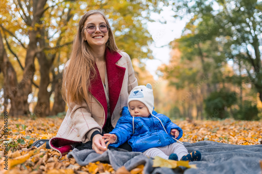 Happiness mom with little baby in the autumn park