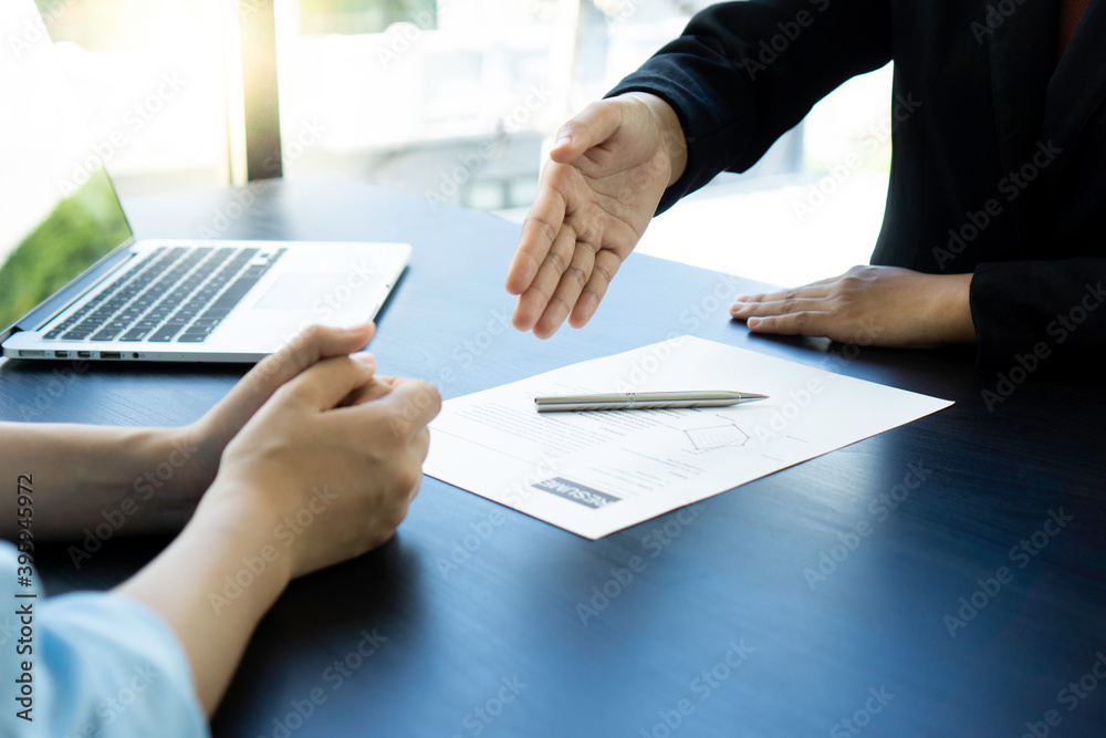 A female finance worker sitting opposite the manager gets a handshake. To express the pleasure that has passed the selection of persons to work in the company, concept of congratulation In recruiting A female finance worker sitting opposite the manager gets a handshake. To express the pleasure that has passed the selection of persons to work in the company, concept of congratulation In recruiting
