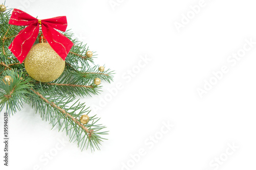 Christmas decoration, shiny yellow ball with a red bow on a Christmas tree branch isolated on a white background
