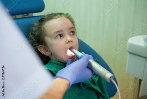 Child at the dentist s appointment. Doctor s appointment. Little girl treats teeth