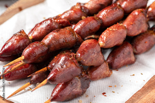 Grilled chicken hearts on a skewer close-up. 