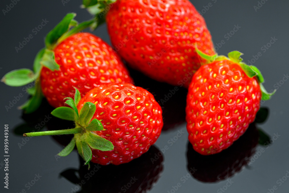 Macro image of fresh red strawberries group isolated at black background with reflection. Macro image of fresh red strawberries group isolated at black background with reflection.