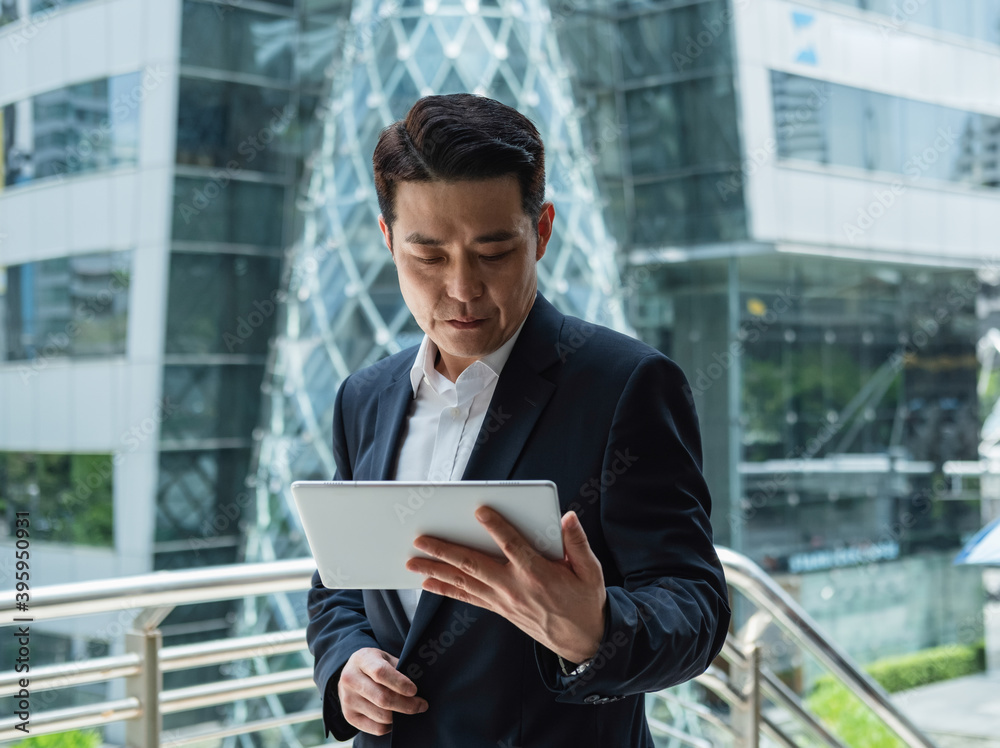 Portrait of serious business man using digital tablet in business district Portrait of serious business man using digital tablet in business district
