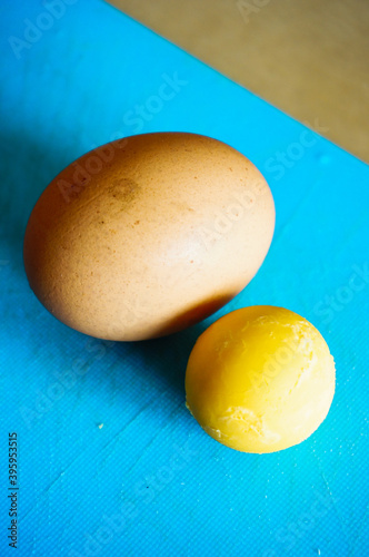 Vertical shot of a boiled egg and yellow yark on the table photo