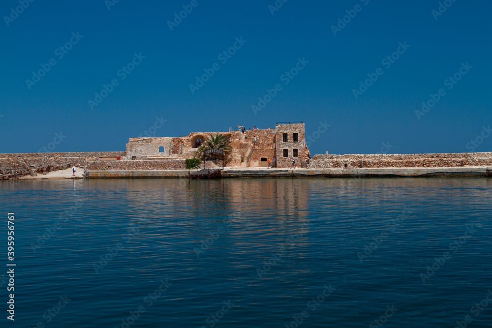 sea and waves on the surface and rocks and mountains during the day is blue sky in the sky clouds in greece