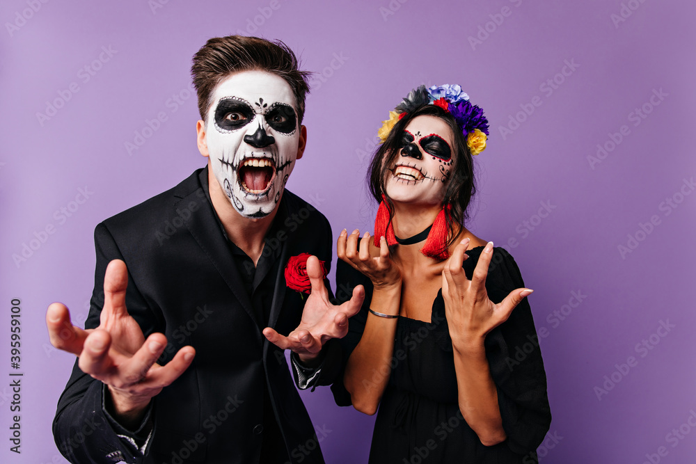 Φωτογραφία Angry boy and girl in masks of skull emotionally pose, wanting to show their greatness