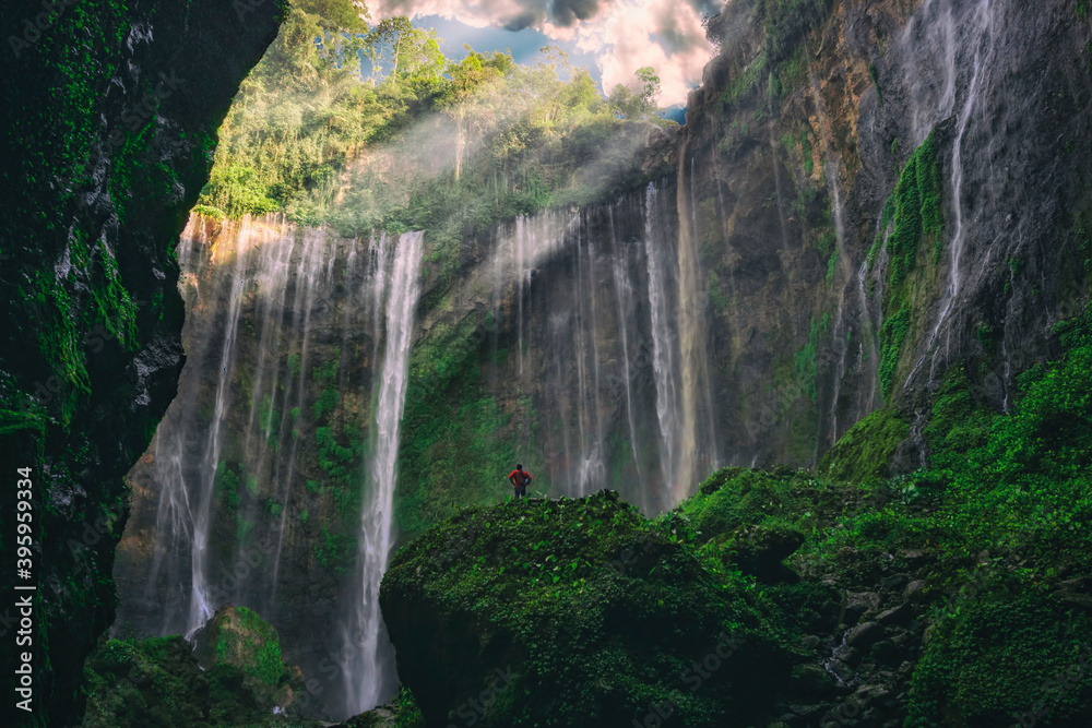 Fototapeta premium A hiker enjoys the view of beautiful Waterfall