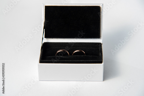 gold wedding rings in the white box with black fabric isolated on a white background