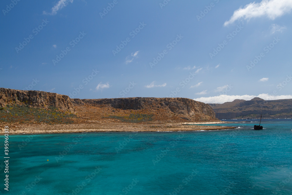 sea and the waves break on the rock and in the background is a mountain and clouds and a blue sky during the day sea and the waves break on the rock and in the background is a mountain and clouds and a blue sky during the day