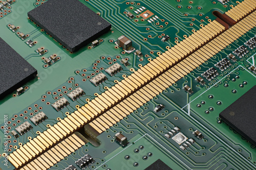 Pair of DDR memory located gold contact connectors to each other. Two green PCB with RAM chips, smd resistors and capacitors close up. Macro shot with high depth of field.