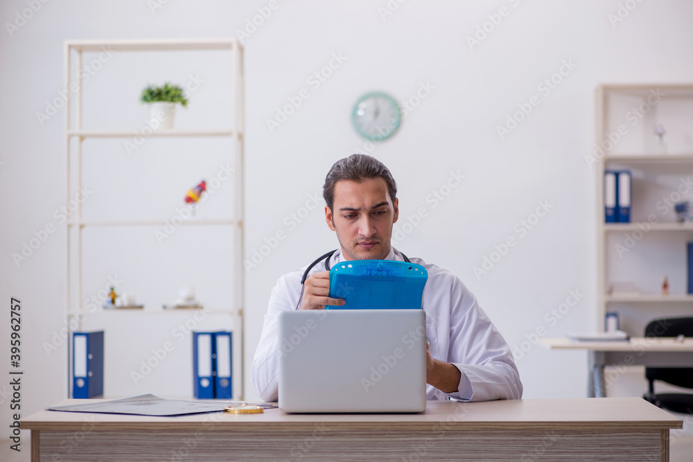 Young male doctor taking notes at the hospital Young male doctor taking notes at the hospital