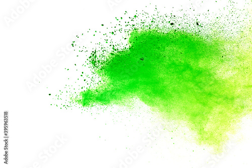 Freeze motion of green color powder exploding on white background.