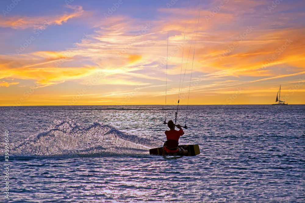 Naklejka premium Kite surfing at Palm Beach on Aruba island in the Caribbean Sea at sunset
